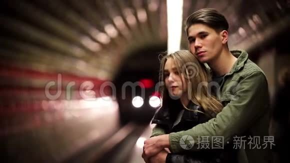 一对年轻夫妇站在地铁里等火车视频