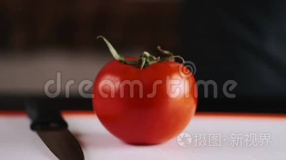 一个新鲜的西红柿正在用刀切视频