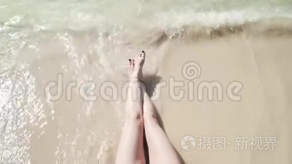 女人`双腿被泡沫般的海浪拍打着