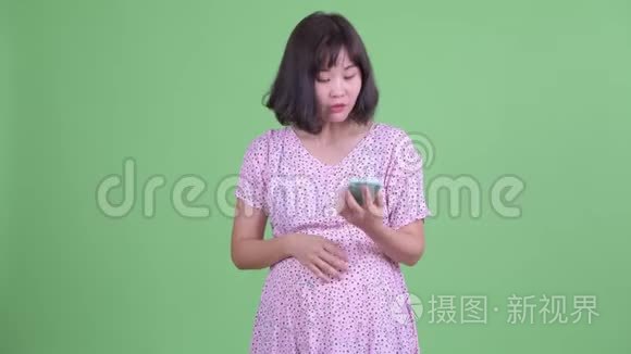 快乐的亚洲孕妇打电话