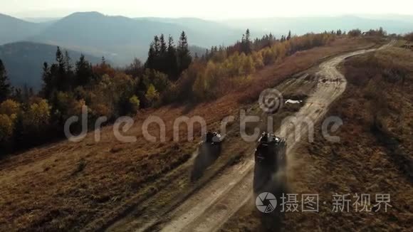 四辆自行车和越野车在山路上行驶。 晴朗的秋日。 空中观景。