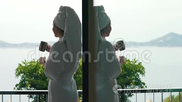 穿着浴袍的女孩喝咖啡俯瞰大海视频