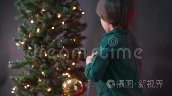 孩子在圣诞树上挂了一个圣诞玩具..