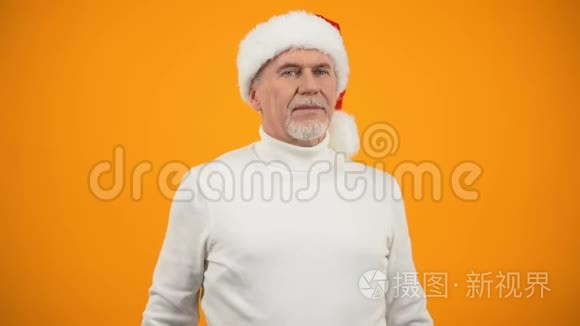 戴着圣诞老人帽子的乐观老人在镜头前微笑，新年庆典