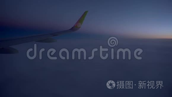 在飞机内观看，乘客窗口，座位，飞机机翼，令人惊叹的日落日出，金色的云