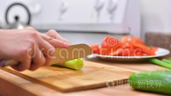女人用菜刀在木板上切鲜黄瓜