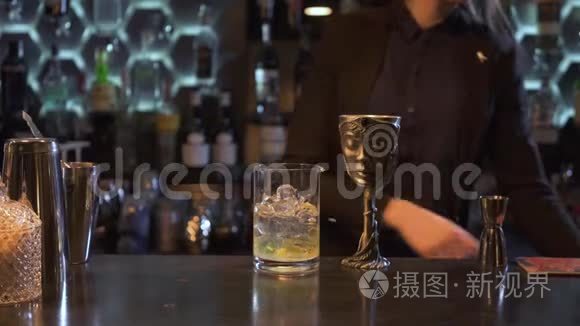 一位棕色长发的酒保女孩将柠檬汁挤在一杯加冰的鸡尾酒里，并将其放在独一无二的金属碗里