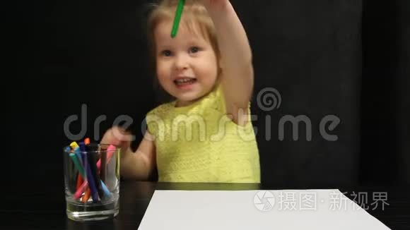 小女孩用绿色铅笔在纸上画画