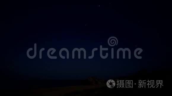 夜晚的星空。 天空中的一颗流星.. 泡沫波浪冲刷海岸。