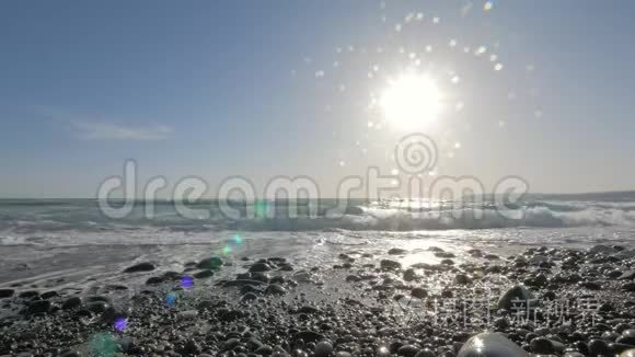 令人惊叹的海景，海浪冲刷鹅卵石海滩，在明亮的阳光下观看