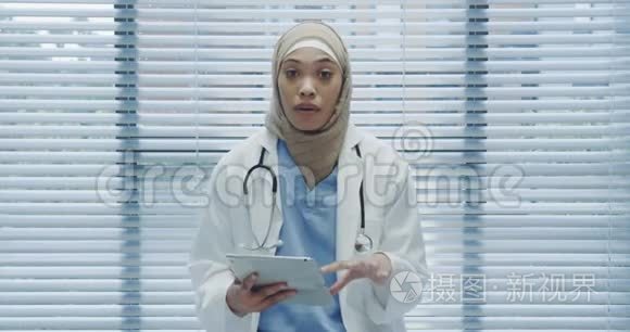 年轻的女医生用平板电脑和摄像机交谈