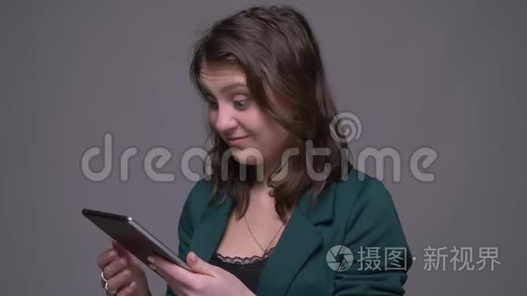 用平板电脑拍摄成年有吸引力的黑发女性的特写镜头，并显示绿色彩色关键屏幕和应用