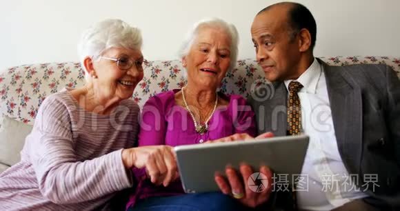 一群活跃的混血高级朋友在养老院讨论数字平板电脑