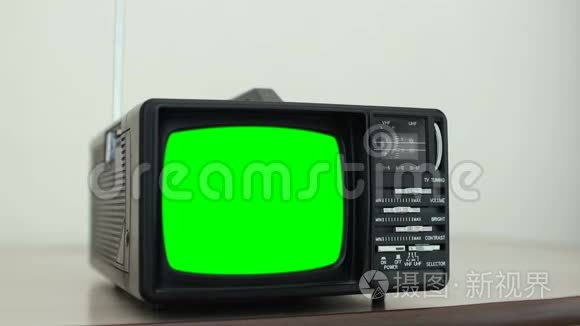 带绿色屏幕的小型复古电视，转换频道