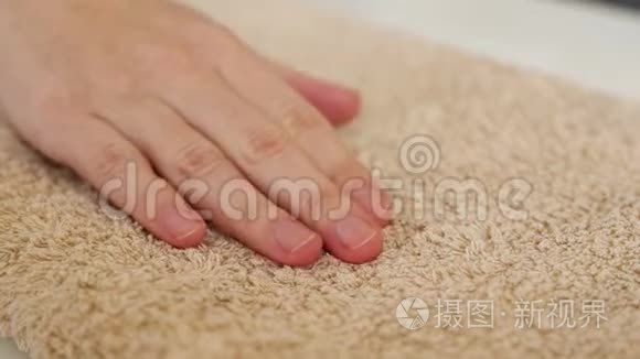 一只手摸着一条毛巾，温暖而蓬松，柔软。 清洁概念