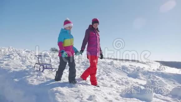 幸福的家庭母亲和孩子女儿在户外散步雪橇。 妈妈和孩子们的美丽家庭