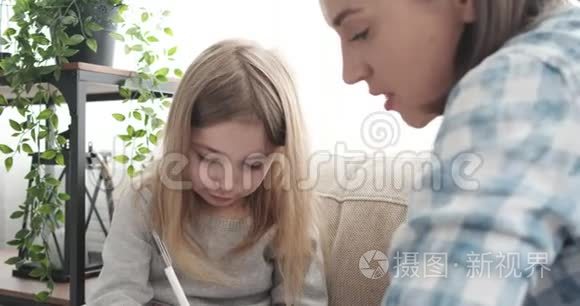 妈妈和小女孩在家用钢笔写字