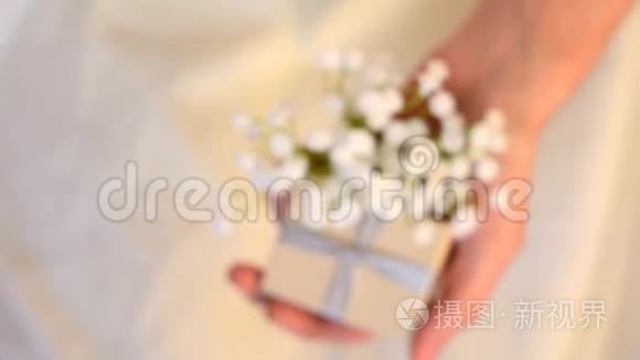 女性手拿小礼盒和白花特写视频