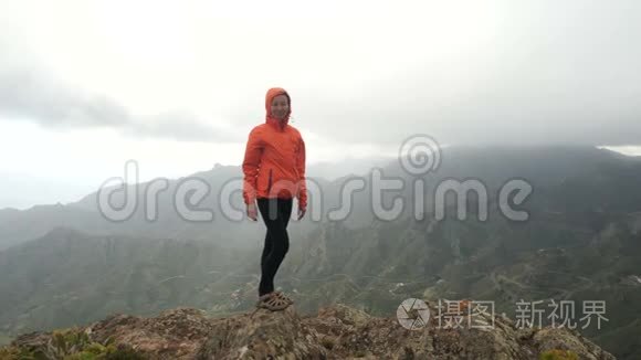 年轻女子在山顶的岩石上平衡，在美丽的风景中，在仙人掌和热带植物之间。 夫人