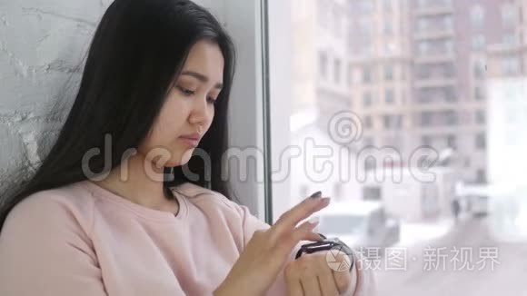 年轻的亚洲女人用智能手表浏览视频