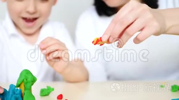 快乐的孩子和他的妈妈一起玩塑料或面团