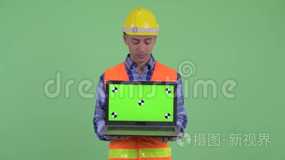 多民族建筑工人展示笔记本电脑视频