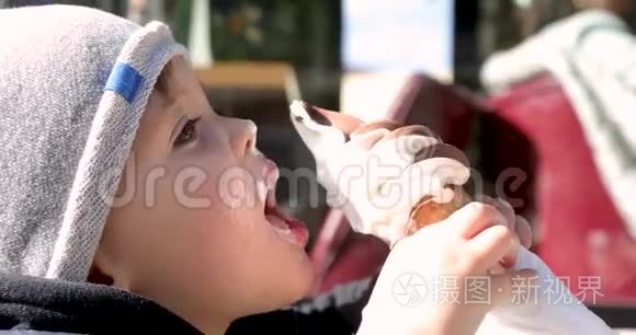 可爱的小男孩在蛋筒里舔冰淇淋