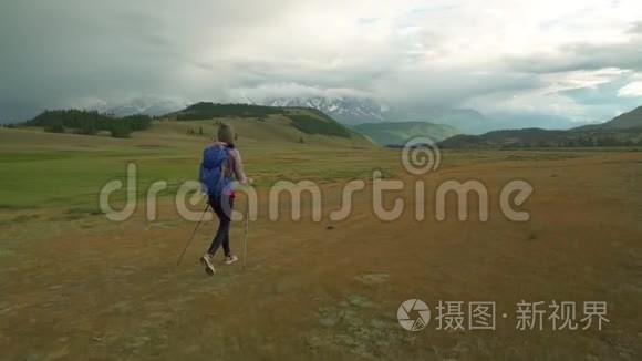 女人徒步旅行。 在山上远足。 带背包的女旅行者在美丽的夏季景观上。