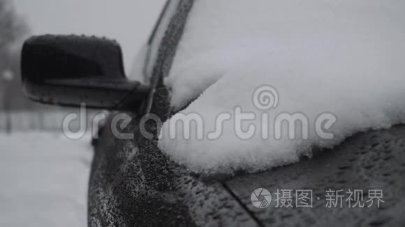 冬天降雪时，雪落在汽车`引擎盖上. 恶劣的天气条件，交通，暴风雪。 危险