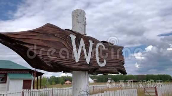一个户外木制箭头标志WC，公共厕所标志在乡村公园