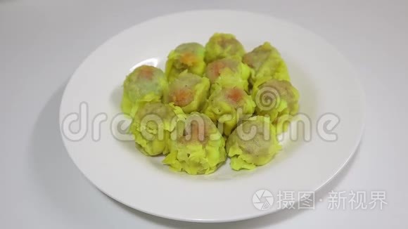 黄色的饺子放在白色的盘子里，上面撒着大蒜