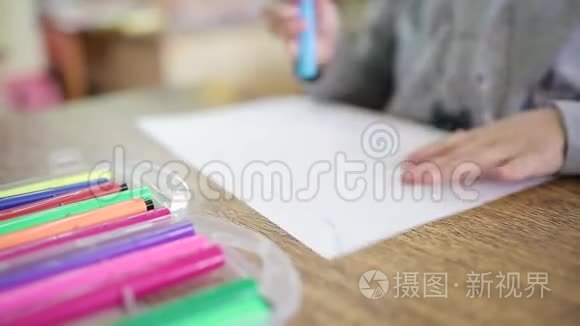 幼儿将毛毡尖笔放在一个盒子里，盒子里多种颜色的毛毡尖笔.. 孩子们在课堂上画画