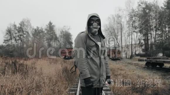 戴着防毒面具的人站在废弃的火车站。 世界末日概念