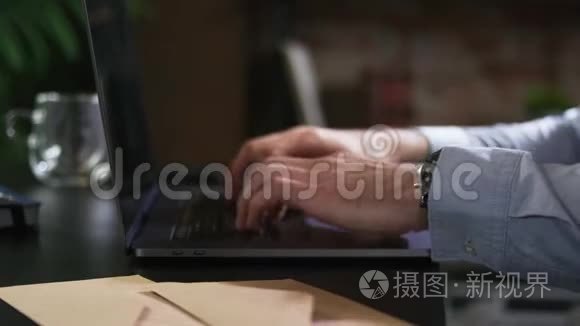 一个男人在办公室里用笔记本电脑工作，在键盘上输入文字并关闭笔记本电脑的封面