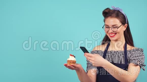 快乐的糕点女孩为她的纸杯蛋糕拍照