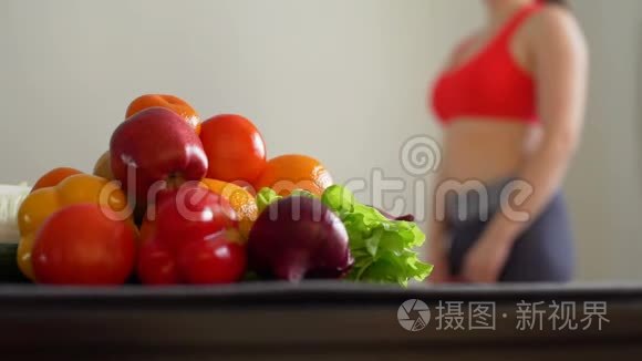 运动妇女在健康食品附近测量腰部