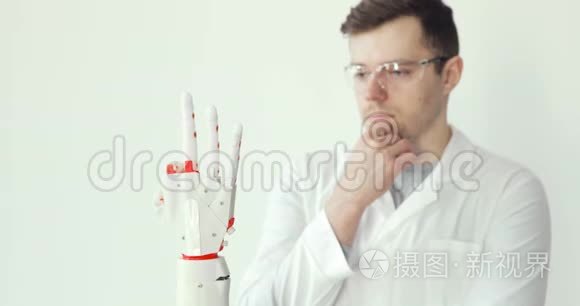 工程师科学家正在测试用手指做运动的机器人假体手。 用心研究它`如何