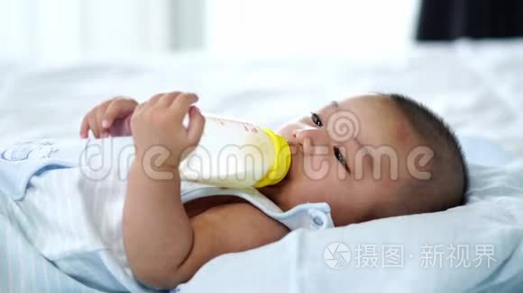 婴儿在床上喝牛奶