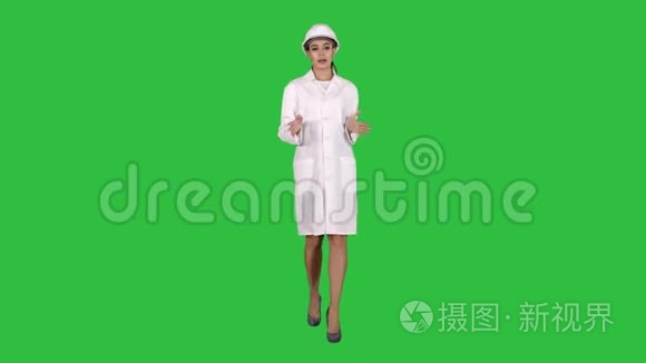 女工程师走路和与镜头交谈，呈现在绿色屏幕上的东西，铬键。