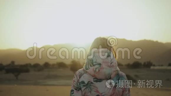 美丽的金发女人在沙漠中日落时散步。 女性穿越沙漠，沙丘，特写，慢动作，4k