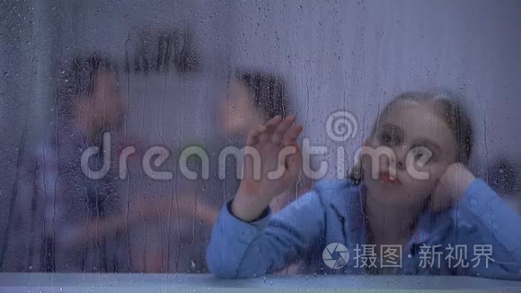 沮丧的女孩坐在雨窗后，父母在后台争吵