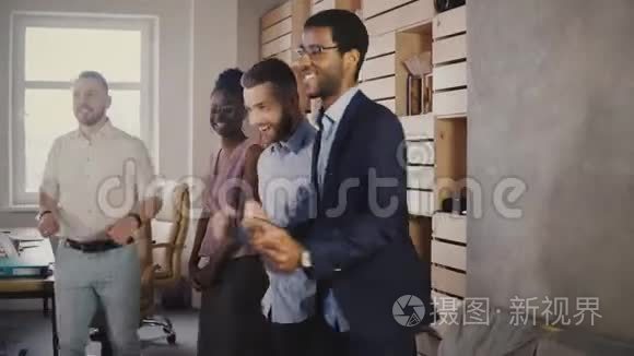 快乐的非裔美国人高管与同事在休闲办公室聚会上跳舞，庆祝商业成就4K。