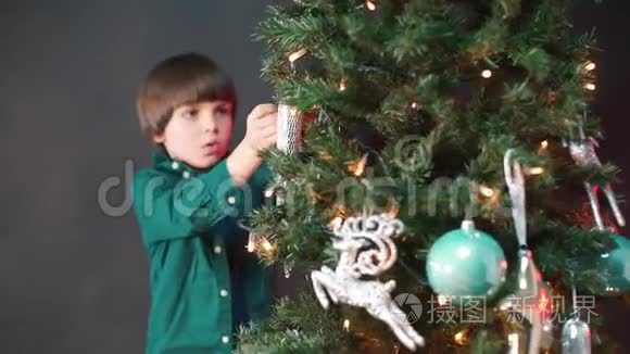 漂亮的孩子把玩具挂在圣诞树上。