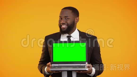 穿着正式西装的美国黑人男性，手里拿着预先准备好的笔记本电脑，微笑着，哇
