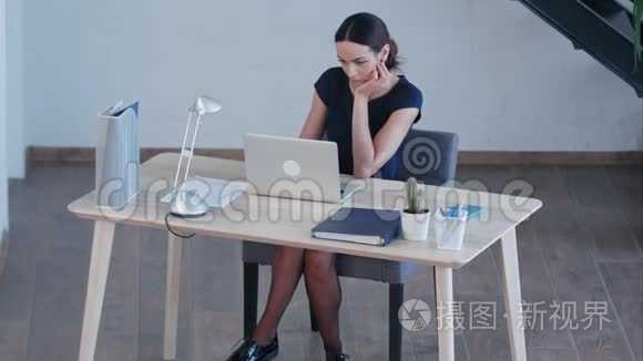 有魅力的商业女性在大型阁楼工作室使用笔记本电脑
