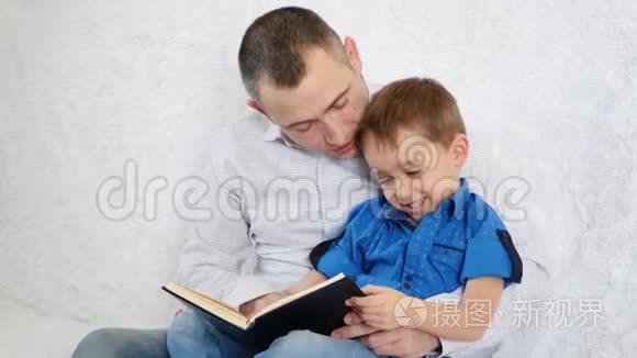 幸福家庭：一位父亲和他的儿子正在读一本有趣的书。