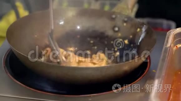 厨师用平底锅煎出细条食物