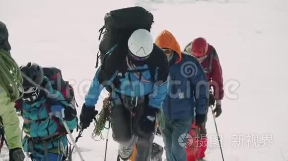 登山队员在雪地疲劳中协同登山视频