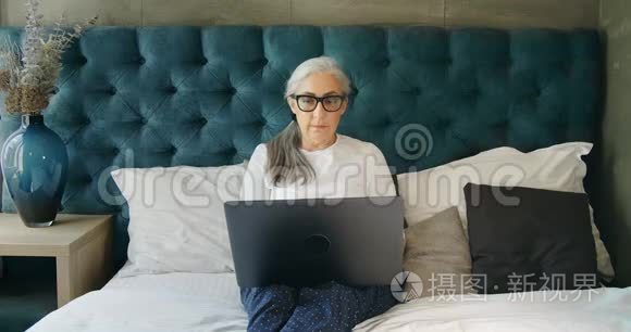 在笔记本电脑上工作的老年妇女视频