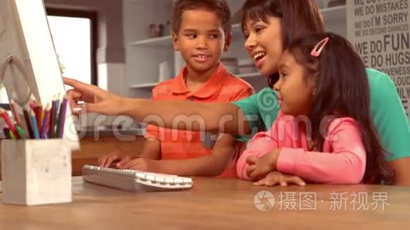 带着孩子在电脑上微笑的西班牙母亲